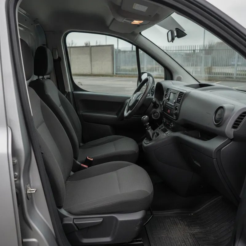 The front cab interior of a small panel van, showing the driver and passenger seats