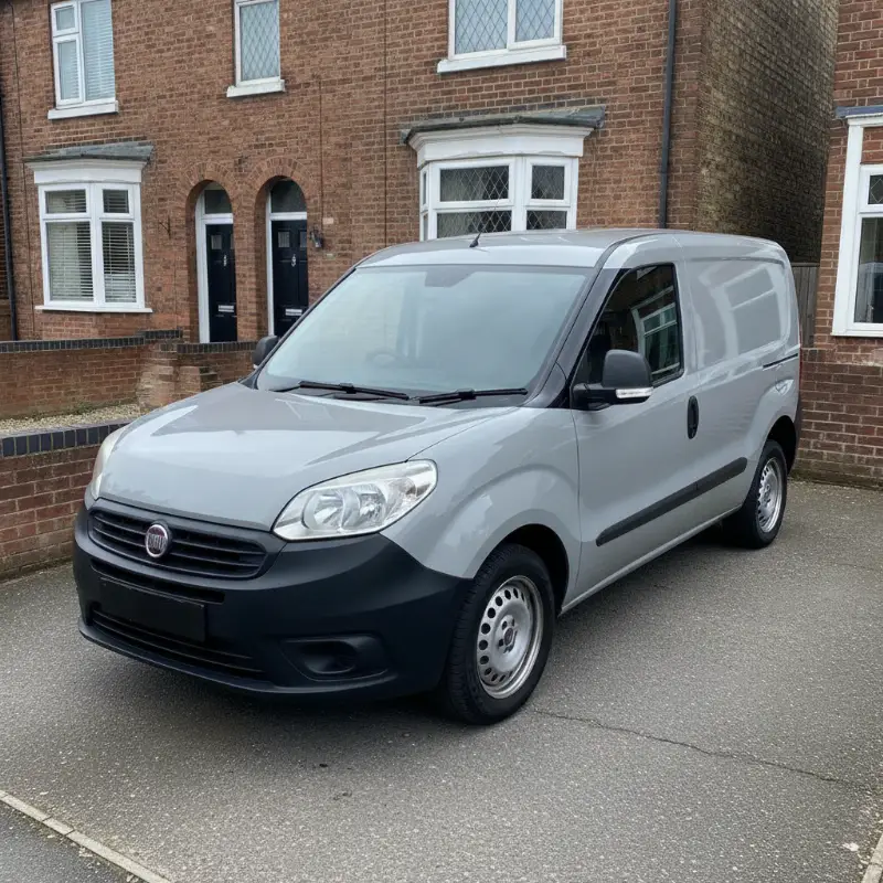 A Fiat Doblo small van parked on a driveway in front of a UK terraced house